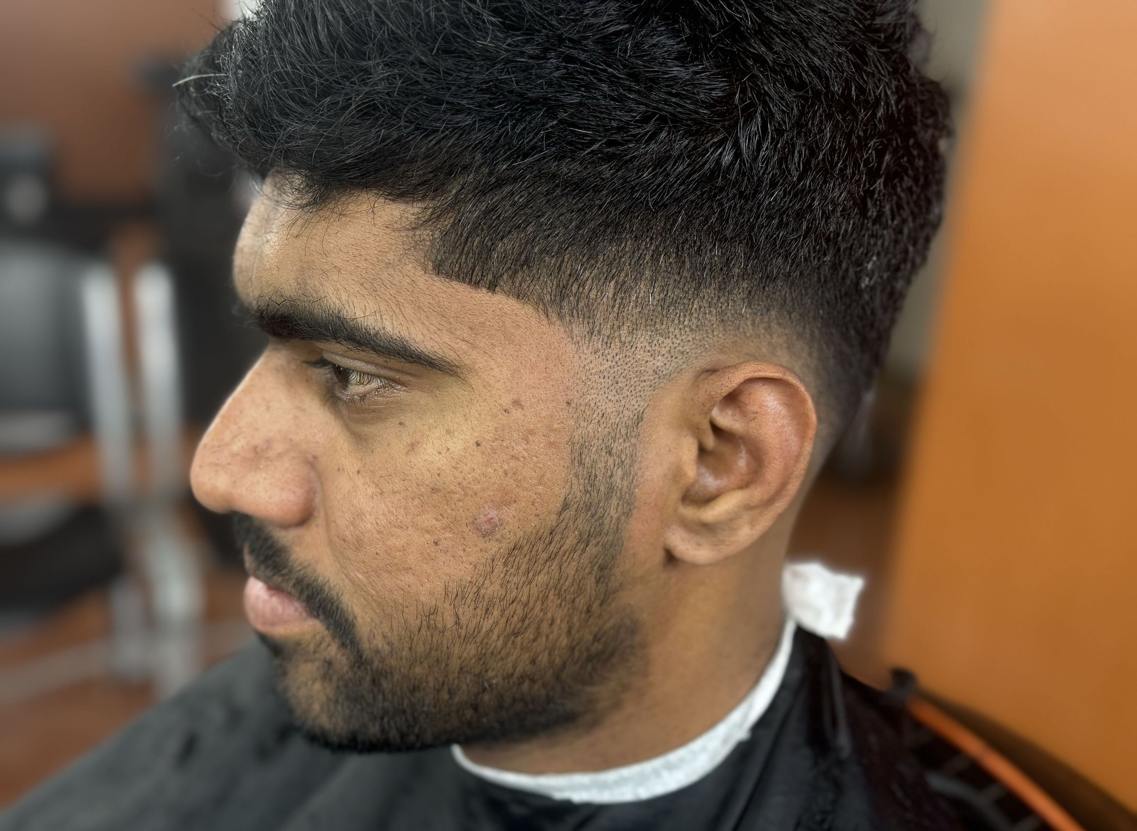 Low fade with short textured top and beard by Big Shawn — Rocky's Primetime Barbershop Atlanta