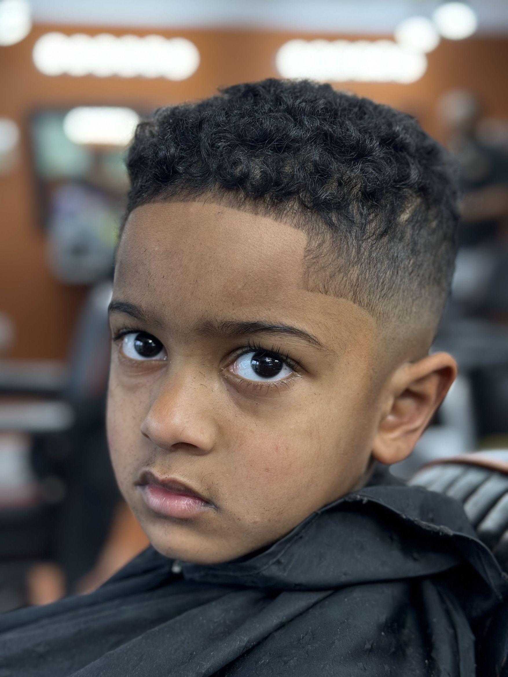 Kids curly top with skin fade and lineup by MJ — Rocky's Primetime Barbershop Atlanta