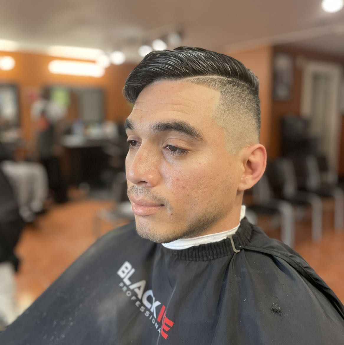 Side part comb-over with skin fade by MJ — Rocky's Primetime Barbershop Atlanta