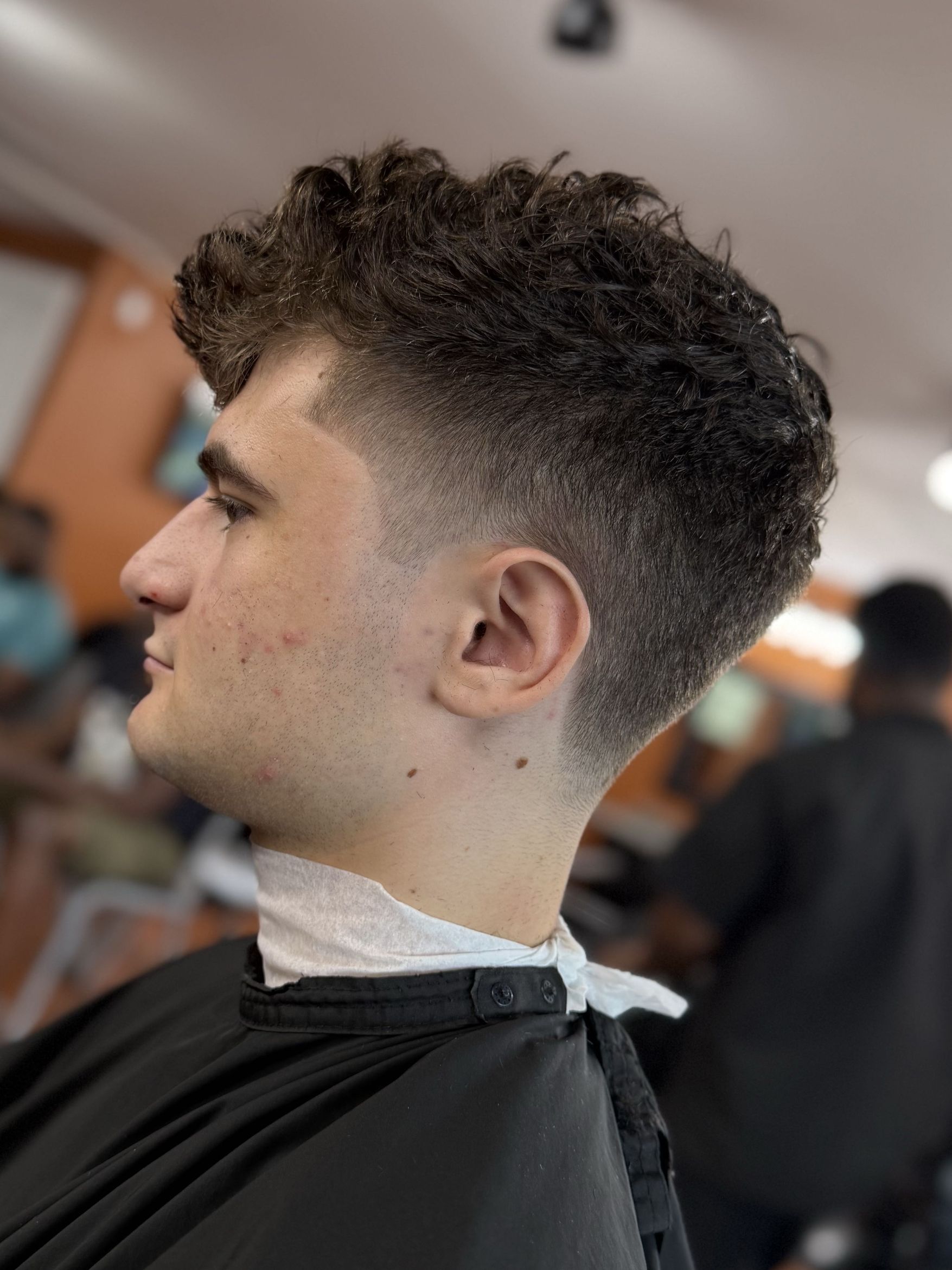 Textured curly crop with taper fade by Rich — Rocky's Primetime Barbershop Atlanta